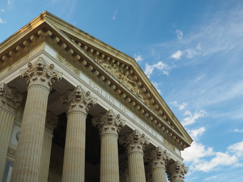 Classical courthouse columns against a clear sky